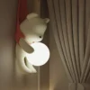 Creme-estilo-resina-urso-l-mpadas-de-parede-LED-n-rdico-quarto-de-crian-a-luzes-1 Luminária Infantil (Quarto Bebê), Arandela Urso segurando Bola Branca